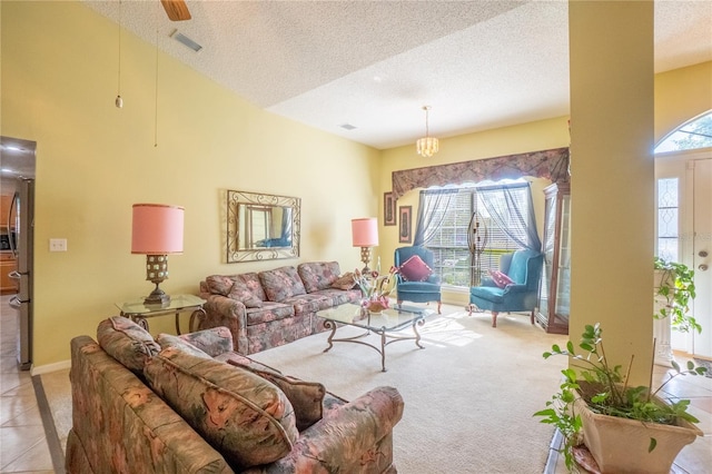 tiled living area with carpet flooring, visible vents, a textured ceiling, and baseboards