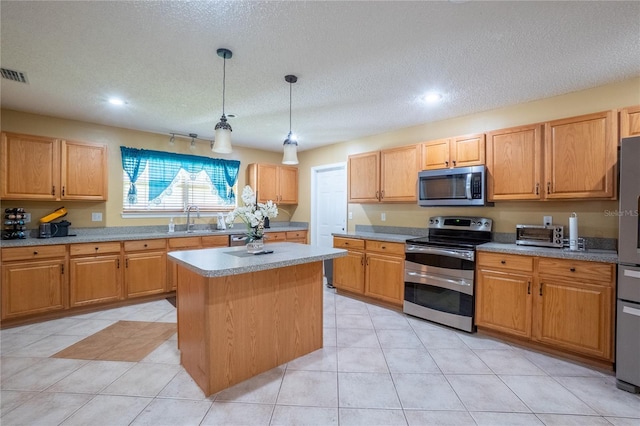 kitchen with a sink, appliances with stainless steel finishes, a textured ceiling, recessed lighting, and a kitchen island