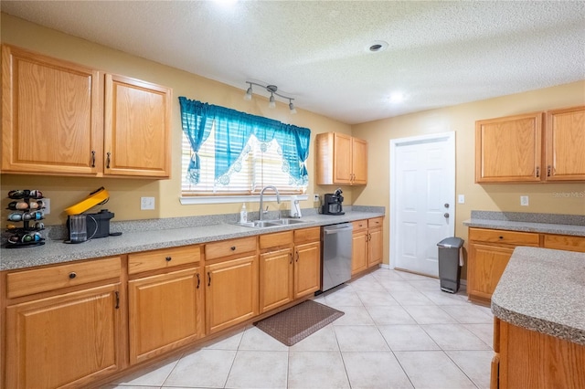 kitchen with light tile patterned floors, a sink, light countertops, a textured ceiling, and stainless steel dishwasher