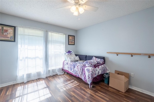 bedroom with baseboards, ceiling fan, wood finished floors, and a textured ceiling