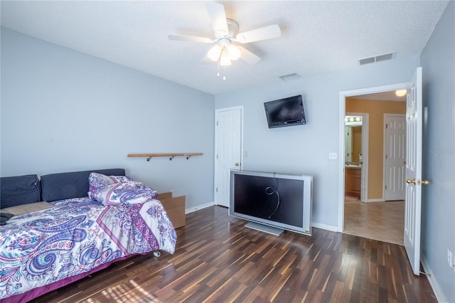bedroom featuring visible vents, ceiling fan, baseboards, and wood finished floors