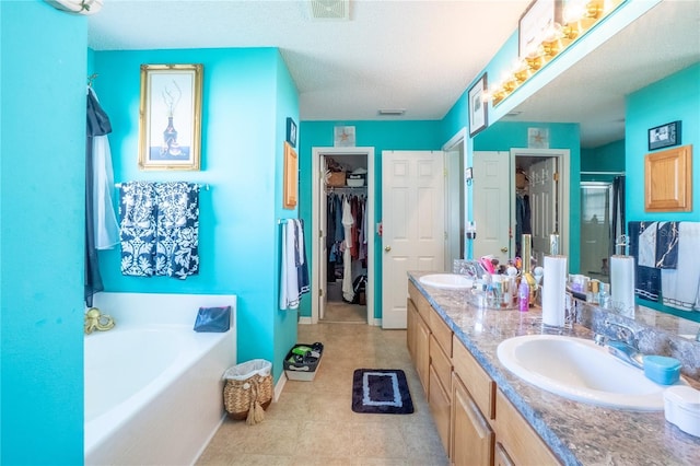 bathroom featuring a sink, a walk in closet, a bath, and a shower stall