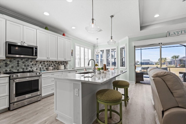 540 Good Life Way, Daytona Beach, FL 32124 - kitchen with appliances with stainless steel finishes, a sink, open floor plan, light wood-style flooring, and ornamental molding