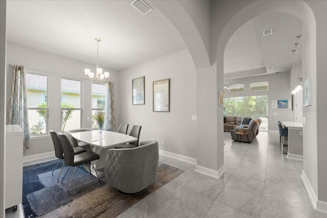 dining room featuring visible vents, arched walkways, and a healthy amount of sunlight