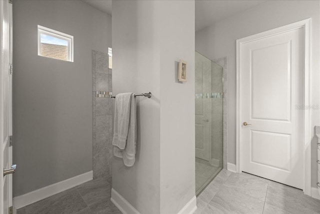 bathroom with baseboards and tiled shower