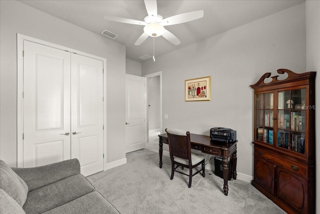 office area with baseboards, visible vents, light colored carpet, and a ceiling fan