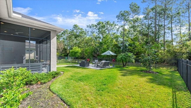view of yard with a sunroom, a patio, and a fenced backyard