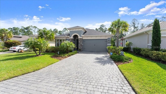 view of front of property with stucco siding, stone siding, decorative driveway, an attached garage, and a front yard