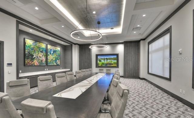carpeted home theater room with a tray ceiling, baseboards, and recessed lighting