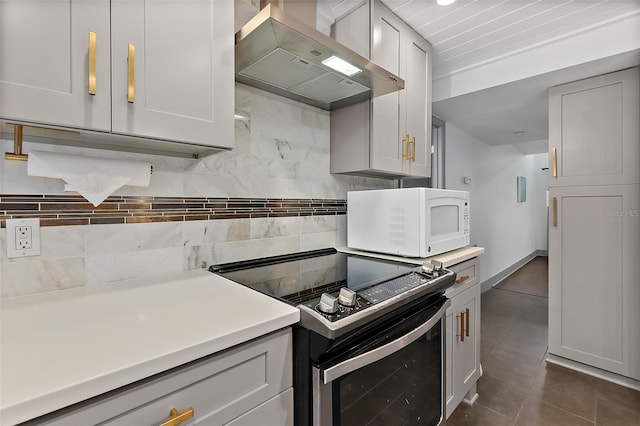 kitchen featuring wall chimney range hood, stainless steel electric range, white microwave, light countertops, and decorative backsplash