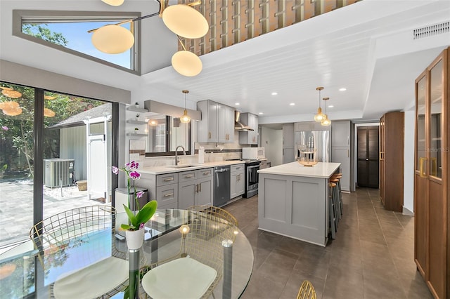 kitchen with light countertops, a sink, gray cabinetry, and stainless steel appliances