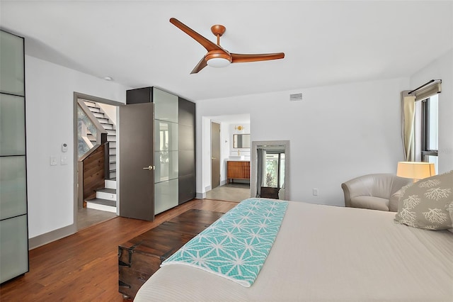 bedroom featuring visible vents, multiple windows, wood finished floors, and a ceiling fan