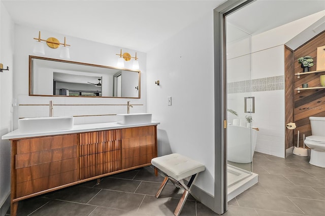 full bathroom with a sink, tile walls, tile patterned flooring, and toilet