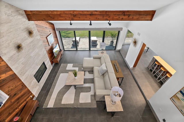 living area featuring a fireplace with flush hearth, visible vents, and beam ceiling