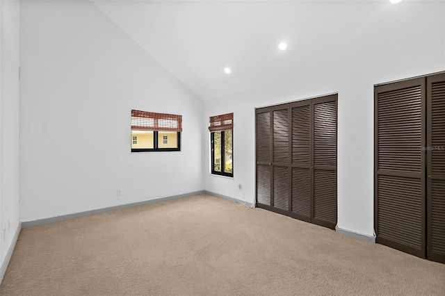 unfurnished bedroom with high vaulted ceiling, carpet floors, recessed lighting, multiple closets, and baseboards