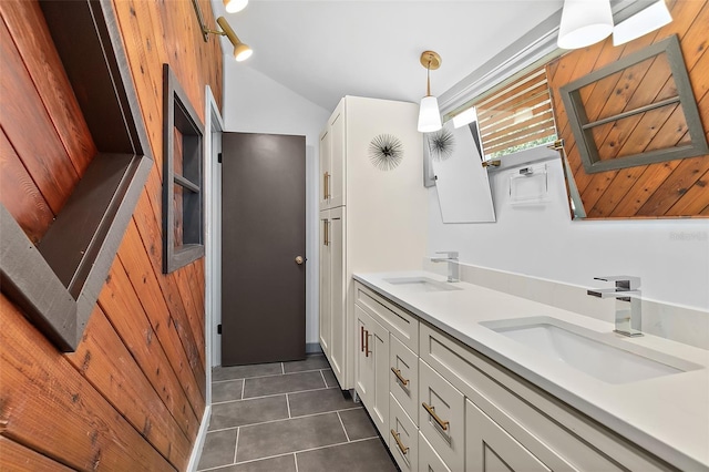 full bathroom with tile patterned floors, double vanity, vaulted ceiling, and a sink