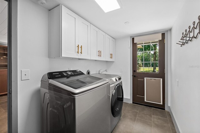 laundry area with cabinet space, dark tile patterned flooring, baseboards, and separate washer and dryer