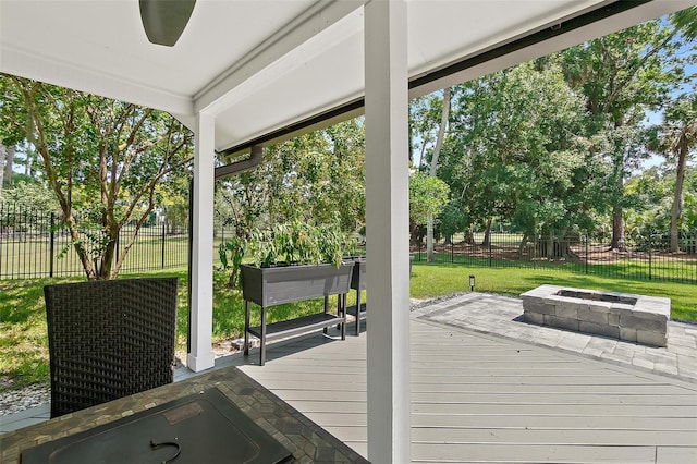 deck featuring a yard, an outdoor fire pit, and fence