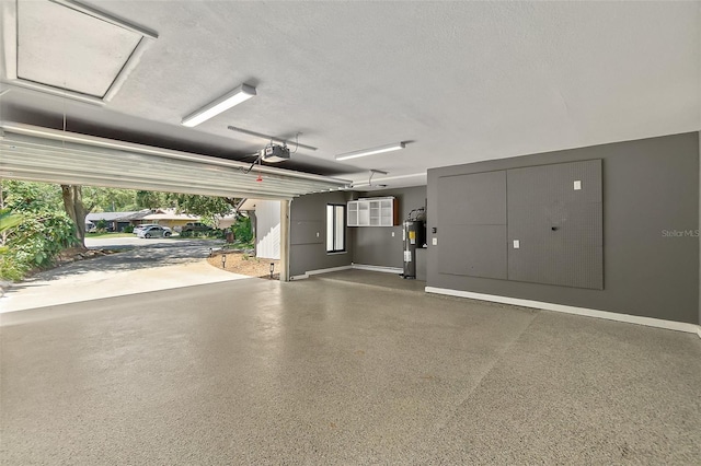garage with electric water heater, baseboards, and a garage door opener