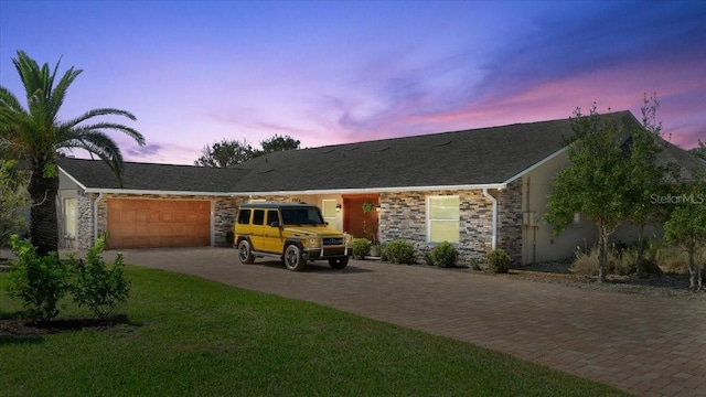 2924 River Point Dr, Daytona Beach, FL 32118 - ranch-style home featuring a yard, an attached garage, stone siding, and driveway