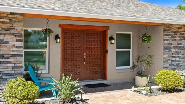 2924 River Point Dr, Daytona Beach, FL 32118 - entrance to property featuring a porch, stone siding, and roof with shingles