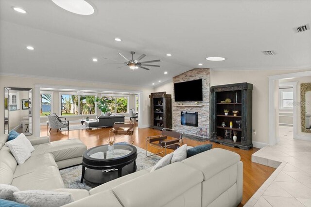 2924 River Point Dr, Daytona Beach, FL 32118 - living area with ornamental molding, a fireplace, a ceiling fan, visible vents, and lofted ceiling
