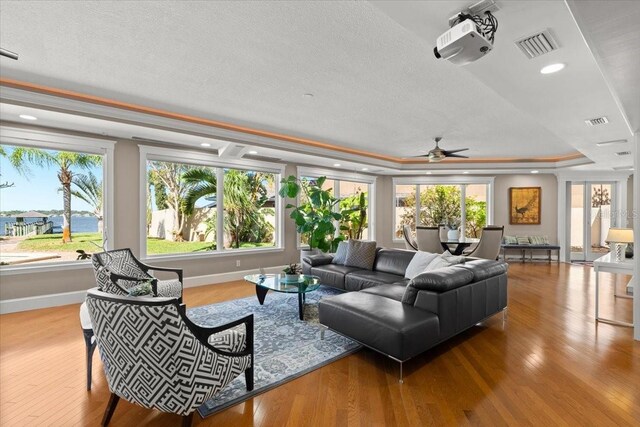2924 River Point Dr, Daytona Beach, FL 32118 - living room featuring ceiling fan, visible vents, wood finished floors, a raised ceiling, and baseboards