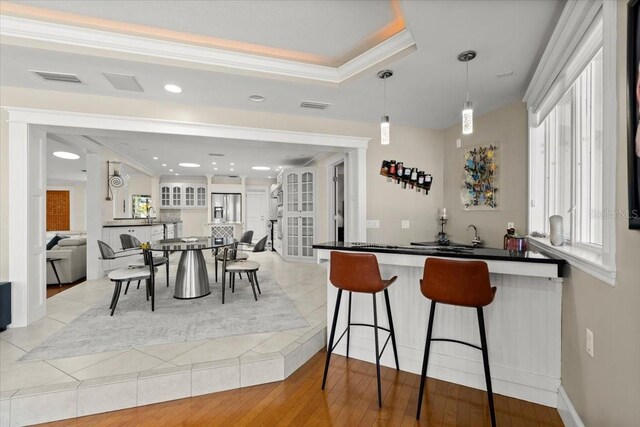 2924 River Point Dr, Daytona Beach, FL 32118 - kitchen featuring visible vents, a kitchen bar, ornamental molding, and dark countertops