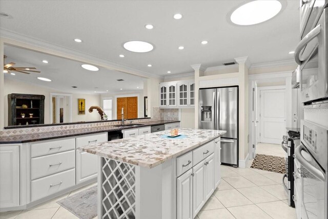 2924 River Point Dr, Daytona Beach, FL 32118 - kitchen with light tile patterned floors, a peninsula, a center island, appliances with stainless steel finishes, and a sink