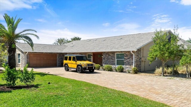 2924 River Point Dr, Daytona Beach, FL 32118 - ranch-style house with decorative driveway, roof with shingles, a front yard, stone siding, and a garage