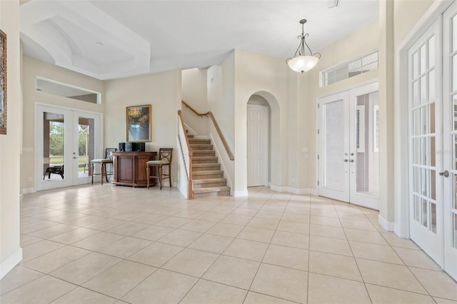 65 Heron Dr, Palm Coast, FL 32137 - tiled entrance foyer featuring a towering ceiling, baseboards, french doors, stairs, and arched walkways