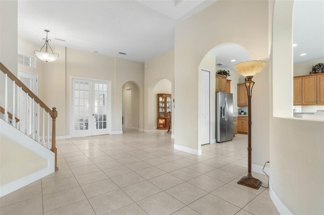 65 Heron Dr, Palm Coast, FL 32137 - foyer featuring arched walkways, stairway, french doors, and light tile patterned floors