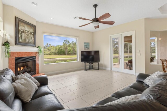 65 Heron Dr, Palm Coast, FL 32137 - living room with light tile patterned floors, baseboards, ceiling fan, a fireplace, and french doors
