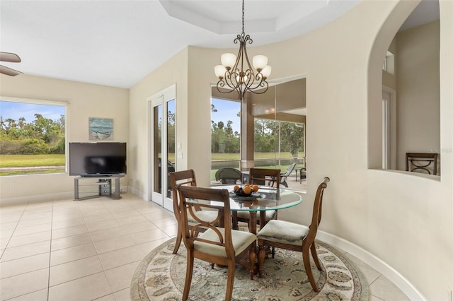 65 Heron Dr, Palm Coast, FL 32137 - tiled dining space featuring a chandelier, arched walkways, baseboards, and a tray ceiling
