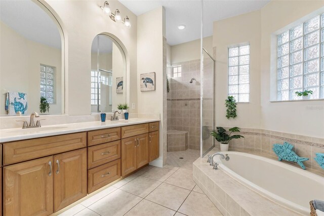 65 Heron Dr, Palm Coast, FL 32137 - bathroom featuring tiled shower, double vanity, a garden tub, and a sink