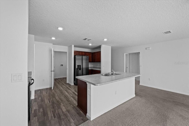 10 Post Oak Ln, Palm Coast, FL 32164 - kitchen featuring stainless steel fridge with ice dispenser, light countertops, a textured ceiling, recessed lighting, and an island with sink