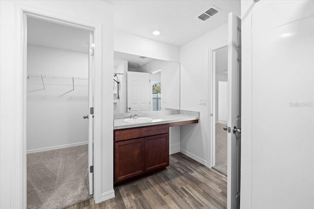 10 Post Oak Ln, Palm Coast, FL 32164 - bathroom with wood finished floors, vanity, a spacious closet, baseboards, and recessed lighting