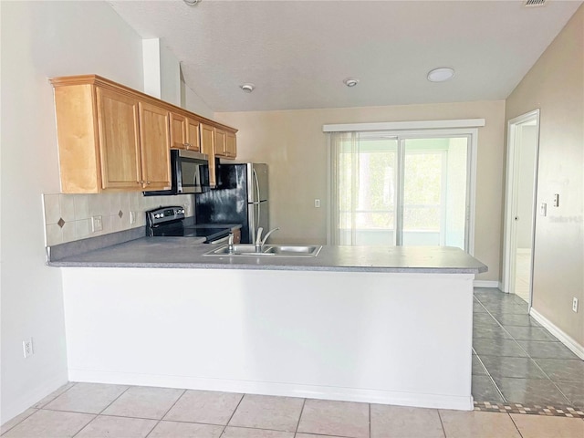 3 Frank Pl, Palm Coast, FL 32137 - kitchen with a sink, appliances with stainless steel finishes, a peninsula, vaulted ceiling, and light tile patterned flooring