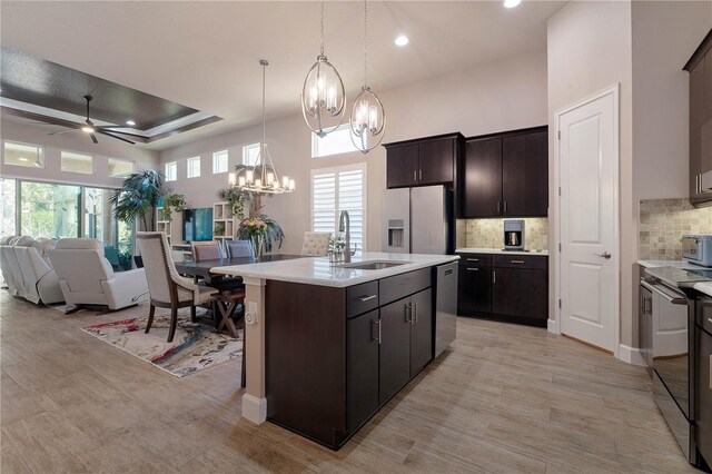816 Creekwood Dr, Ormond Beach, FL 32174 - kitchen featuring backsplash, a sink, appliances with stainless steel finishes, open floor plan, and ceiling fan with notable chandelier