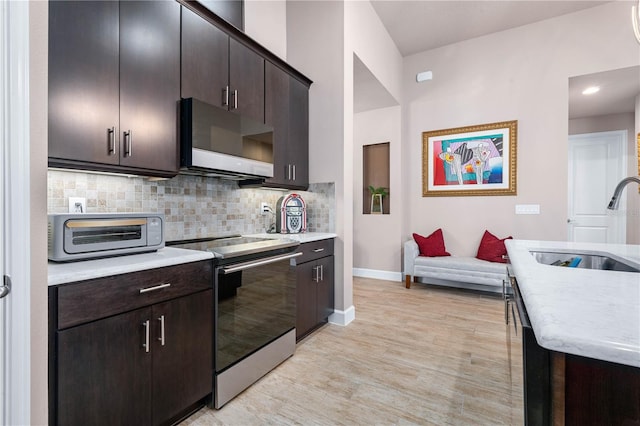 816 Creekwood Dr, Ormond Beach, FL 32174 - kitchen featuring electric stove, a sink, a toaster, backsplash, and baseboards