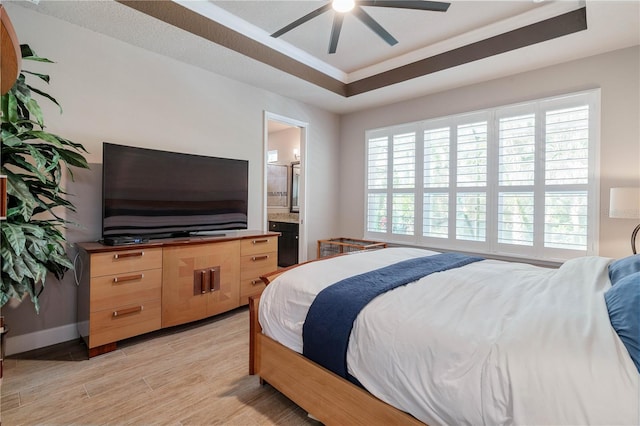 816 Creekwood Dr, Ormond Beach, FL 32174 - bedroom featuring a tray ceiling, light wood-type flooring, ensuite bath, and multiple windows