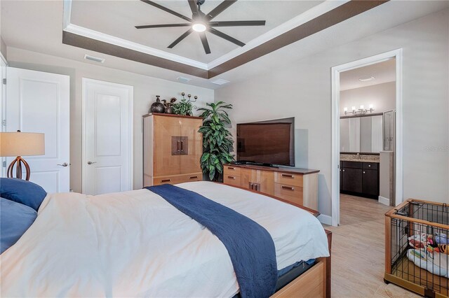 816 Creekwood Dr, Ormond Beach, FL 32174 - bedroom with a raised ceiling, light wood-type flooring, visible vents, connected bathroom, and ornamental molding