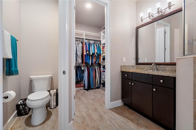 816 Creekwood Dr, Ormond Beach, FL 32174 - bathroom with baseboards, wood finished floors, a spacious closet, and vanity