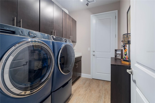 816 Creekwood Dr, Ormond Beach, FL 32174 - clothes washing area with separate washer and dryer, baseboards, light wood-style floors, and cabinet space