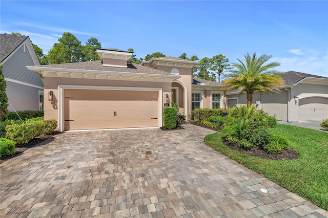 816 Creekwood Dr, Ormond Beach, FL 32174 - mediterranean / spanish home with a garage, a shingled roof, stucco siding, and decorative driveway