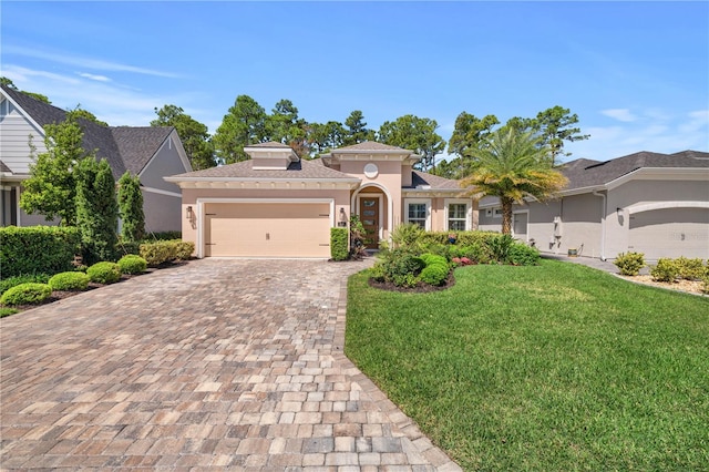 816 Creekwood Dr, Ormond Beach, FL 32174 - mediterranean / spanish house featuring an attached garage, a front yard, decorative driveway, and stucco siding