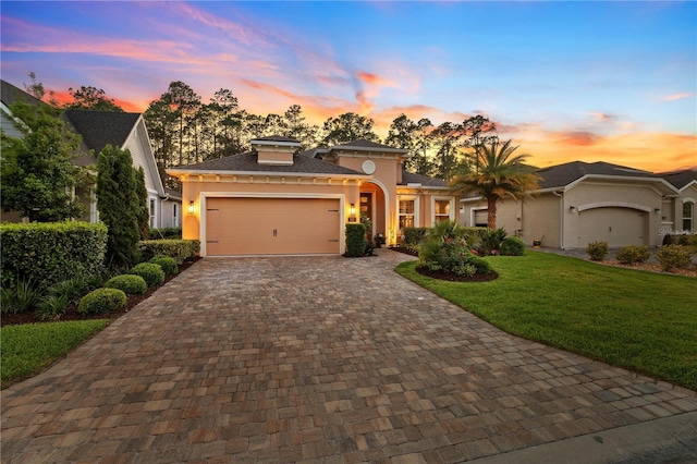 816 Creekwood Dr, Ormond Beach, FL 32174 - view of front of home featuring an attached garage, a lawn, stucco siding, and decorative driveway