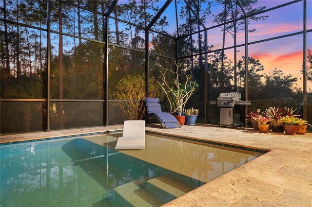 816 Creekwood Dr, Ormond Beach, FL 32174 - pool at dusk featuring glass enclosure, a grill, an outdoor pool, and a patio