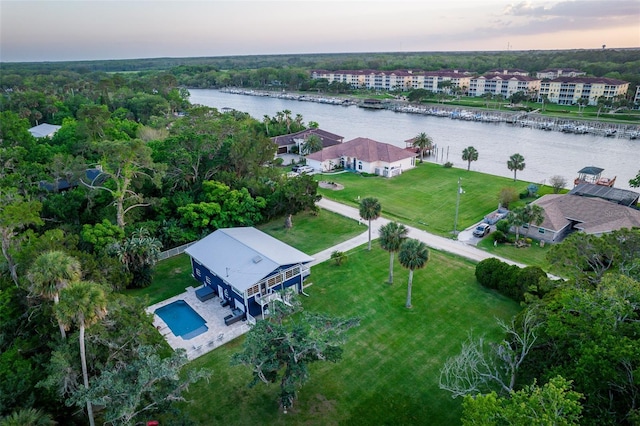 aerial view at dusk featuring a water view