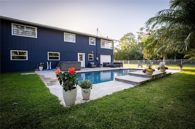 rear view of property with a fenced backyard, a patio area, a hot tub, and a lawn